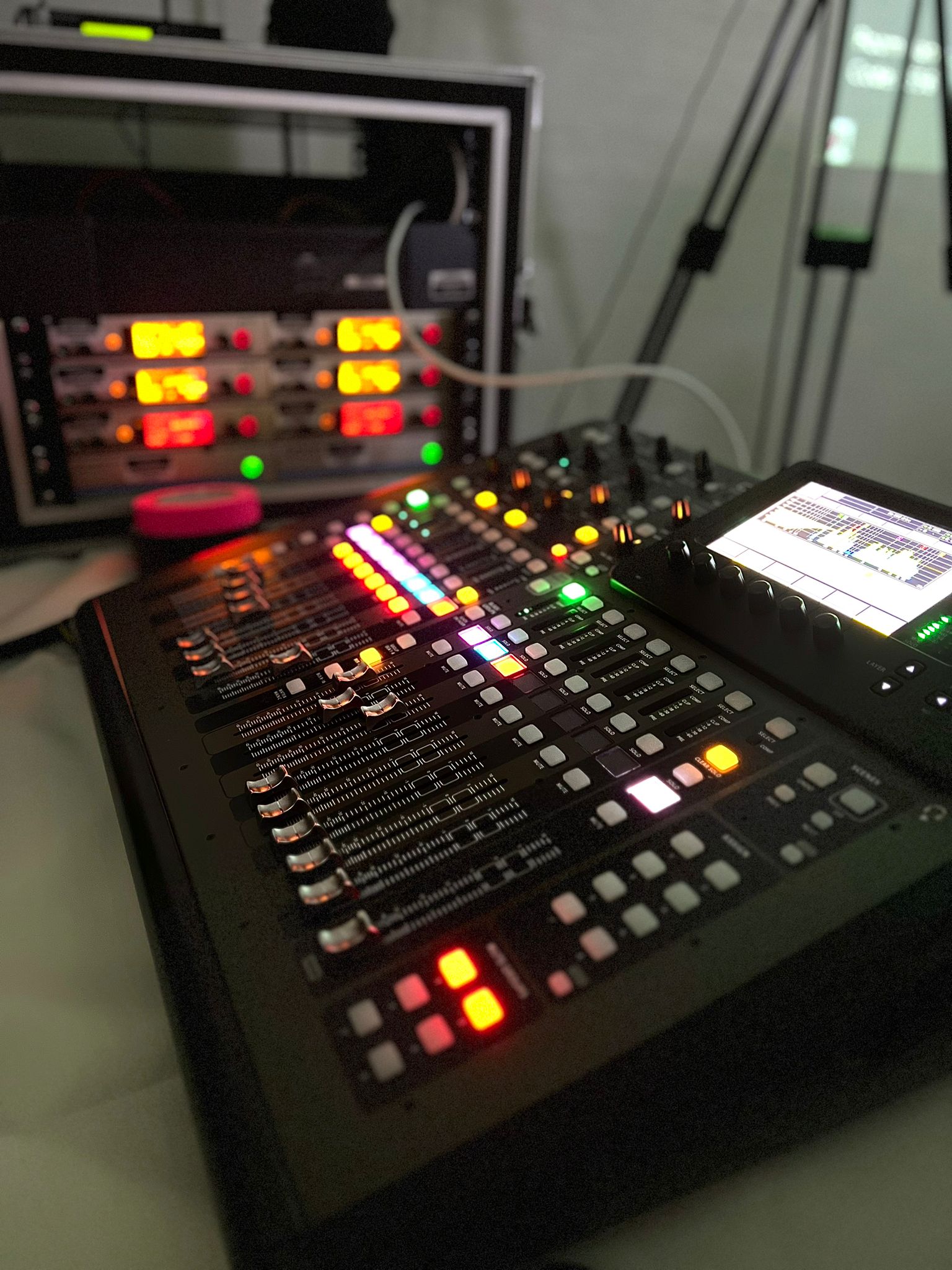 Audio mixing console with colorful LED lights and control panels used in live event sound production.
