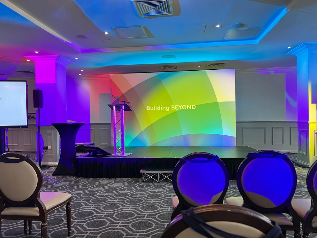 Conference, large audience, event, events, large events, large screens, 85" screen, 86" screen, PA system, wireless microphone, speakers, RCF, handheld microphone, lapel microphone. lighting, backdrop, staging, lectern, stage, Wokefield Estate, Berkshire, Networking event, Set, comfort monitor, AV hire, Audio visual equipment, AVE Services
