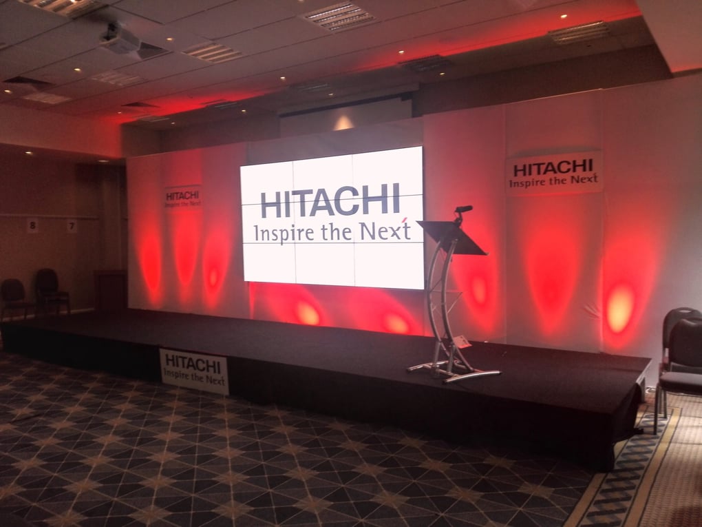 A stage with a podium and a screen with red lights