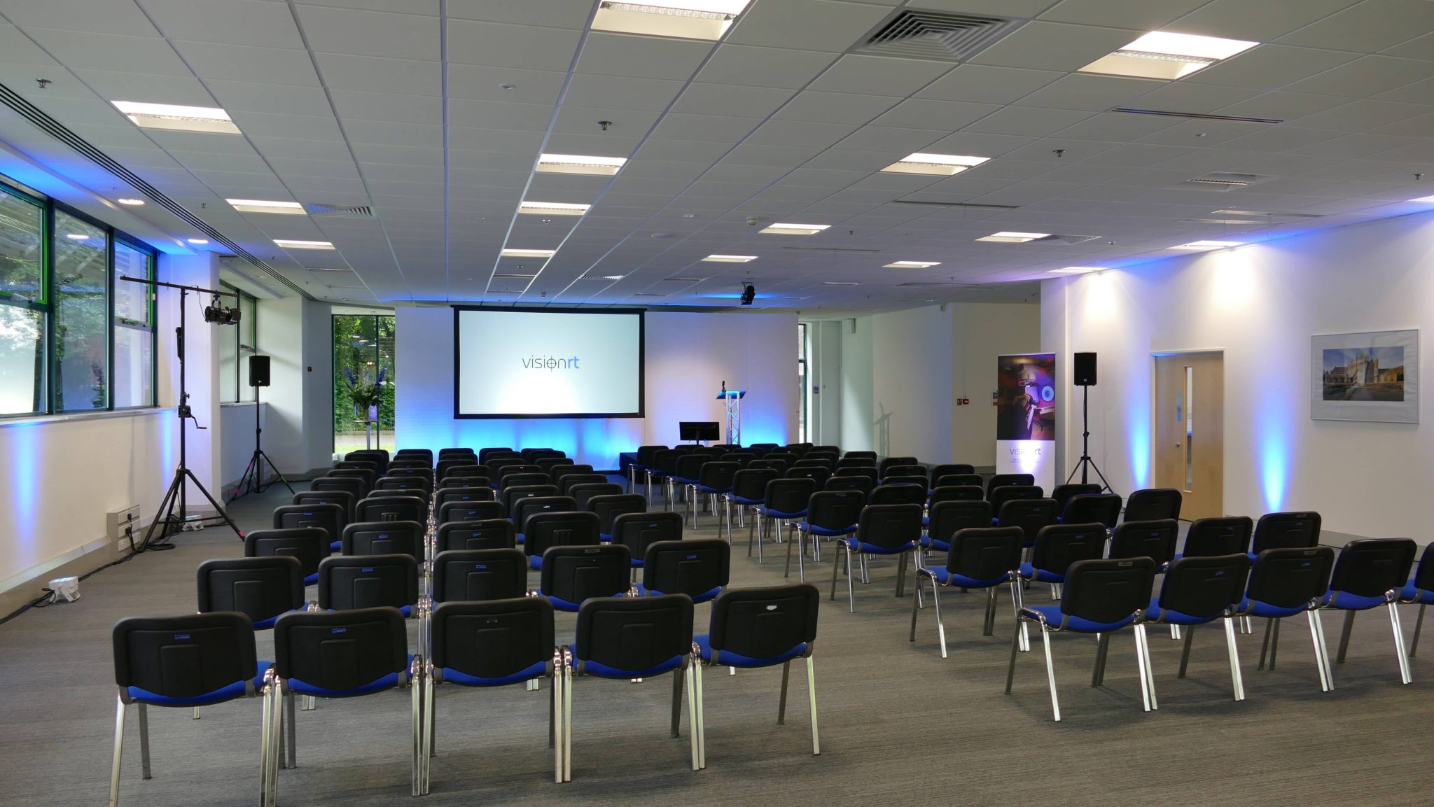 8000 lumen projector, faux leather set panels, 3x2 carpeted stage decks, 28" comfort monitor, 10x6ft rear projection, chair hire, table hire, global live stream to USA offices, video on demand VOD Basingstoke hampshire