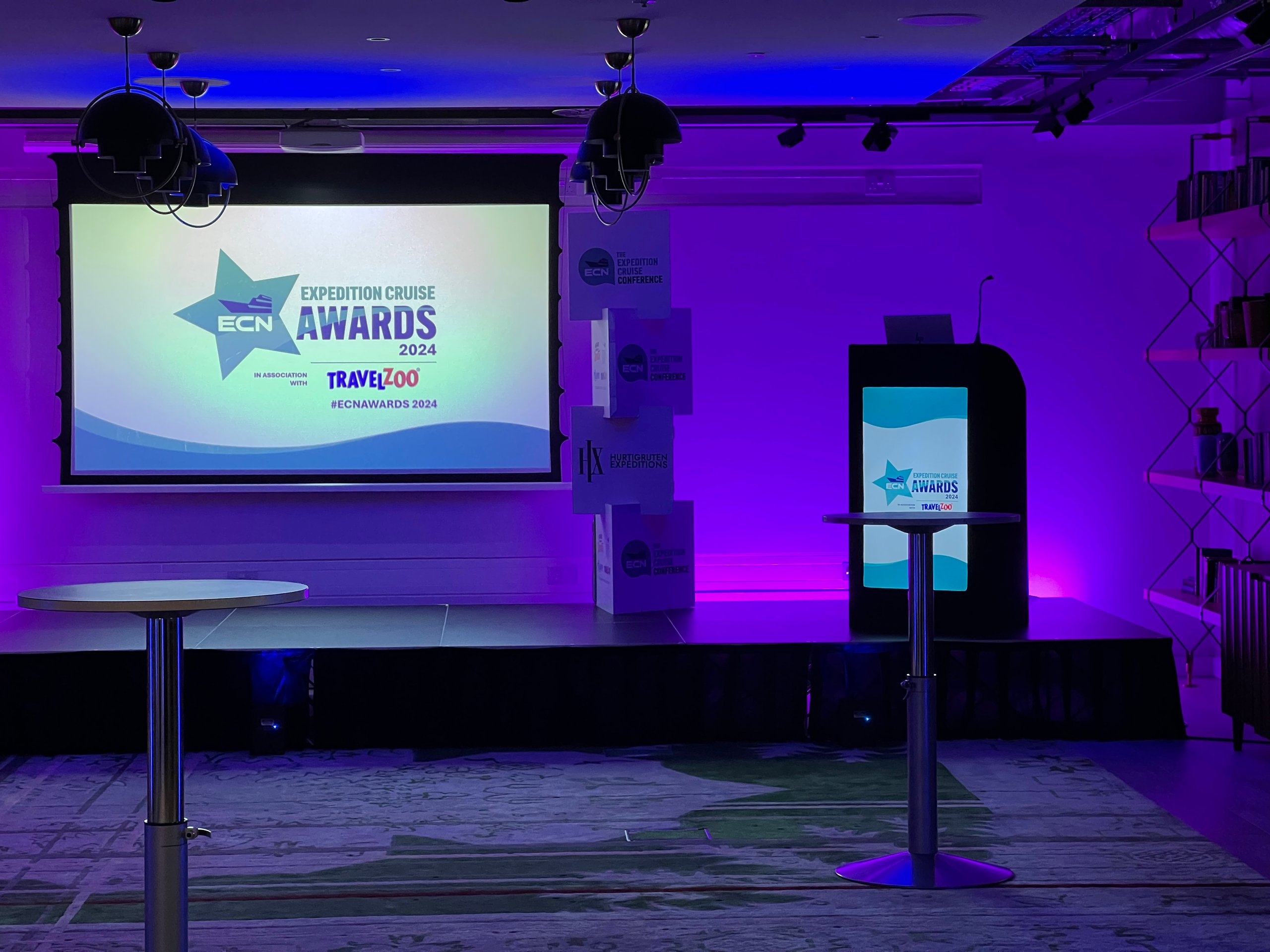Stage setup for ECN Expedition Cruise Awards with podium, projector screen, and event lighting.