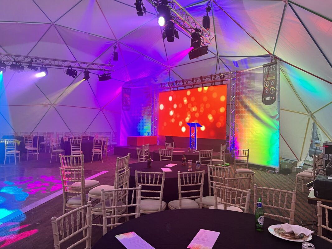 RMS Metro Conference & Awards Show, with large LED videowall, bright rigged lighting in a dome tent