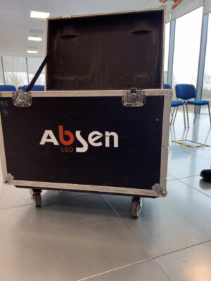 Equipment case on wheels for Absen LED panels in a conference room setting.
